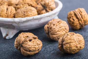 Walnuts in a white bowl on a black background