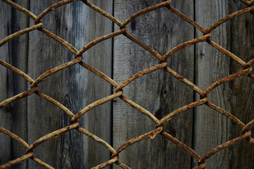 Wire link fence on wooden background