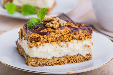 Slice of honey cake on plate and cup of coffee