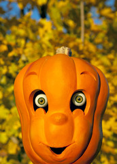 Carved Halloween pumpkin toy with realistic  eyes and a fall tre
