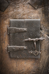 ancient wooden window with metal hinges and a bolt