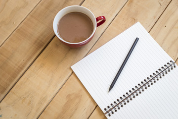 Top view of open book and coffee cup on wooden table