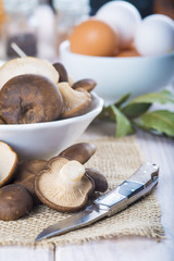 Pleorotus eryngii o setas de cardo con ingredientes para cocinar en la mesa de la cocina