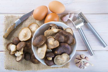 Pleorotus eryngii o setas de cardo con ingredientes para cocinar en la mesa de la cocina