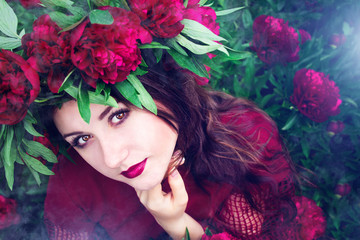 Beautiful woman wearing a wreath of peonies