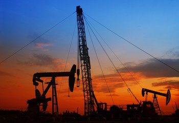 The evening of the oilfield, pumping unit and the silhouette of