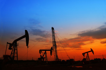 The evening of the oilfield, pumping unit and the silhouette of