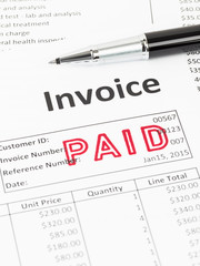 Obraz premium Invoice and pen with paid stamp; document is mock-up