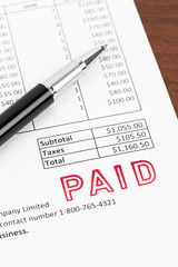 Obraz premium Invoice and pen with paid stamp; invoice is mock-up
