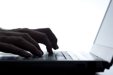Person typing on a laptop keyboard