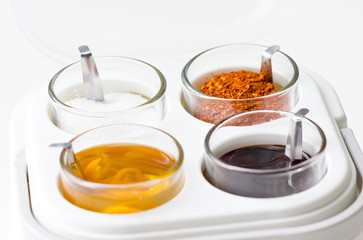 Thai seasoning container include cayenne pepper, sugar, fish sauce and chilies in vinegar.
