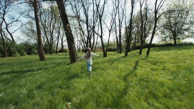 Cheerful Girl Running Away From The Camera In The Park