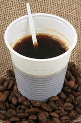 Le gobelet de café noir et des grains de café