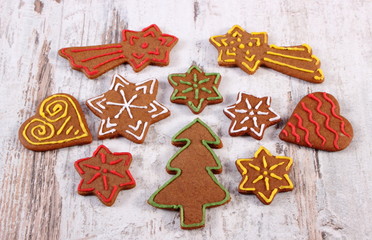 Fresh baked decorated gingerbread on old wooden background, christmas time