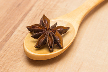 Star anise with wooden spoon on wooden table, seasoning for cooking
