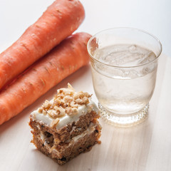 carrot cake with walnuts, prunes and dried apricots on a dark wo