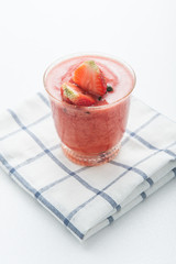 Glass of strawberry smoothie and fresh strawberries
