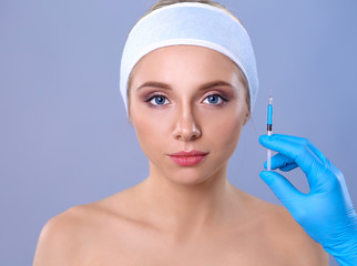 Cosmetic injection on the pretty woman face. Isolated on gray background