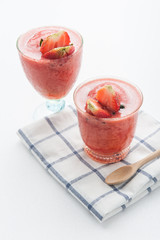 Glass of strawberry smoothie and fresh strawberries