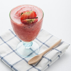 Glass of strawberry smoothie and fresh strawberries