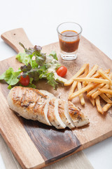 Chicken steak served with french fries and salads to vegetables.
