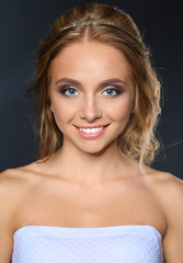 Beautiful woman with curly long hair on dark background