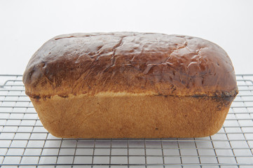 Homemade white bread on a wire cooling rack.