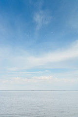 blue sea and cloudy sky over it