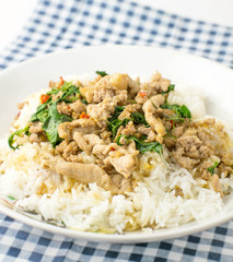 stir fried pork basil and rice on blue tablecloth