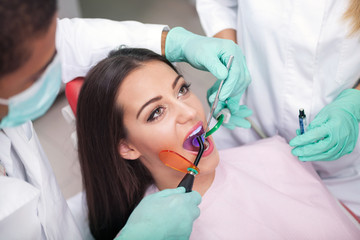 dentist is treating teeth of the female patient