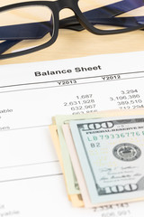 Balance sheet financial report with banknote, and glasses