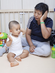 Chinese baby boy playing with grandma