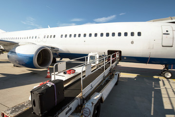 Fototapeta premium Verladung vom Reisegepäck - Koffern in ein Flugzeug // Loading from the luggage - suitcases in an airplane