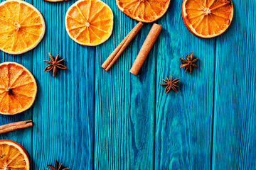 
blue wooden background with orange , cinnamon and spices