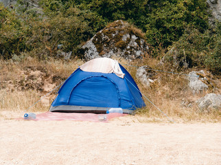 Blue tourist tent standing on the sandy beach