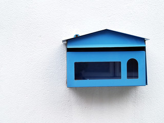 vintage blue steel mailbox with transparent glass on white concrete wall