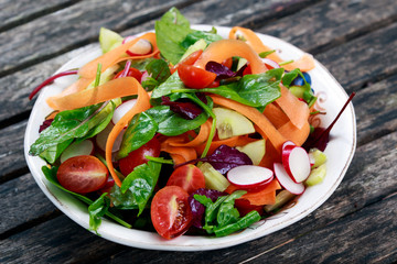 Fresh Vegetable salad on old wooden table.