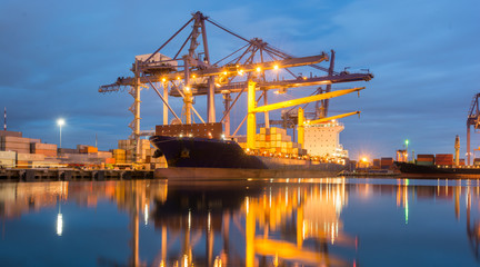 Containers loading by crane at dark sunset