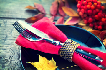 Thanksgiving dinner wooden table served, decorated with bright autumn leaves