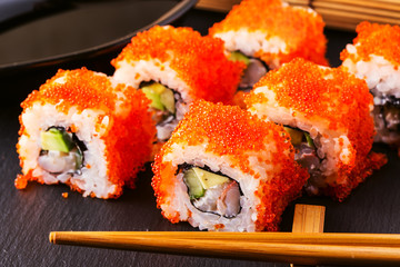 Sushi roll with crab, avocado, cucumber and tobiko.