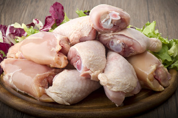 Fresh skinless chicken thighs and legs on cutting board - obrazy, fototapety, plakaty