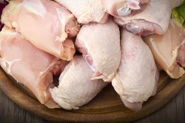 Fresh skinless chicken thighs and legs on cutting board