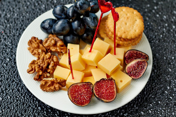 Cheese plate with fruits, walnuts and crackers