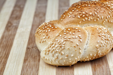 Crispy and perfectly baked sesame bread made of wheat flour. Studio shot on wooden table.