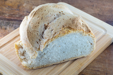 Pane calabrese in primo piano, pane fatto in casa, pane su tagliere, brutto e buono, pane da affettare  su tagliere con coltello