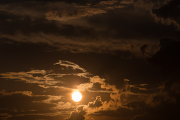 orange sky with sun and black clouds