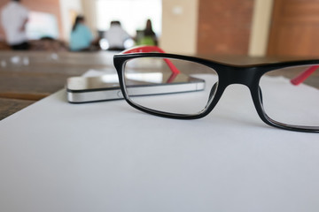 eye glasses placed on a blank paper sheet