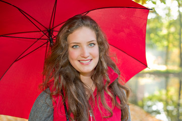 Portrait einer jungen Frau im Herbst mit Regenschirm