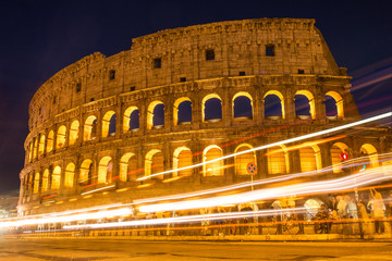Fototapeta na wymiar Colosseum at night with colorful blurred traffic lights. Rome -