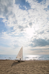 small sailboat on a cart at the beach